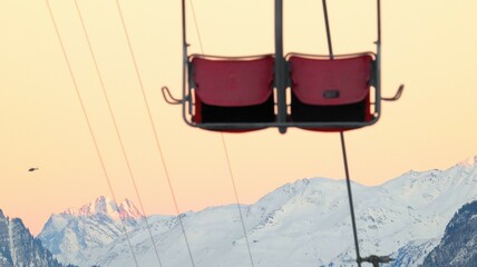 2-seater chairlift with mountains in the background