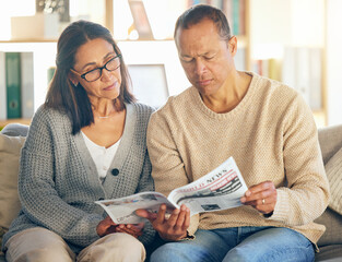 Senior couple, reading and newspaper on sofa, focus or relax together in morning for global event. Mature man, woman or media paper for international news, information or world crisis on home couch