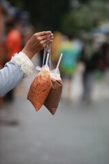 person holding bagged ice tea