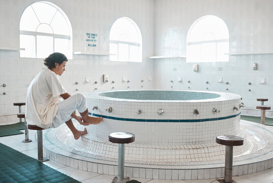 Islam, ablution and man washing before prayer in bathroom at mosque in Iran, spiritual cleaning ritual. Islamic culture, water and worship, muslim guy in cleansing care routine to prepare for praying