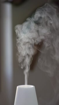 Aroma diffuser with steam at home table in Vertical Video