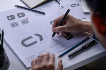 Graphic designer drawing sketches logo design. The concept of a new brand. Professional creative...