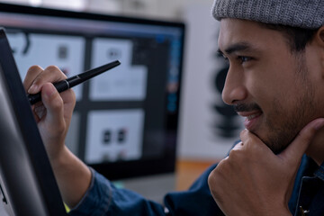 Asian male graphic designer working on computer drawing sketches logo design. The concept of a new...