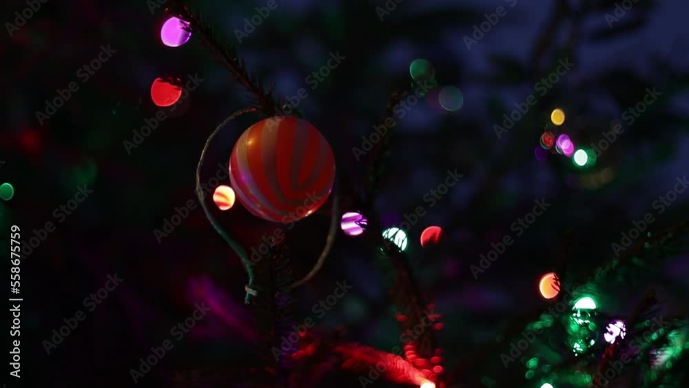 Sticker A Christmas ball hangs on a Christmas tree with a garland at night