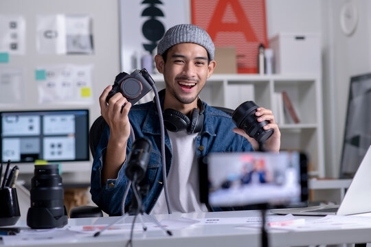 Young Asian Man Graphic Designer Blogger Influencer Filming Teaching Camera Tutorial While Looking At Camera Shooting Education Tutorial Vlog Training Filming Video Course For Social Media At Studio.