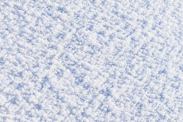 Background of fresh snow texture in blue tone, selective focus, copy space. Fractional snow texture