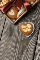 Homemade caramel. Brown caramel candies. Creamy sweets with peanuts. On pine boards. Some of them are packed in a box and tied with a ribbon.