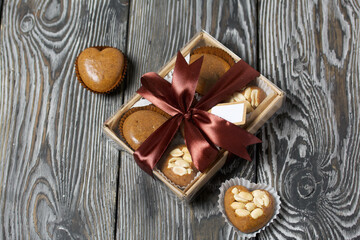 Homemade caramel. Brown caramel candies. Creamy sweets with peanuts. On pine boards. Some of them are packed in a box and tied with a ribbon.