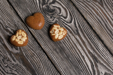 Homemade caramel. Brown caramel candies. Creamy sweets with peanuts. On pine boards.