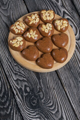 Homemade caramel. Brown caramel candies. Creamy sweets with peanuts. On pine boards.