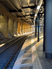 Obraz premium a beautiful old train station in Berlin during sunrise with sun beams on the tracks