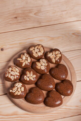 Homemade caramel. Brown caramel candies. Creamy sweets with peanuts. On pine boards.