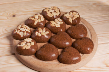 Homemade caramel. Brown caramel candies. Creamy sweets with peanuts. On pine boards.