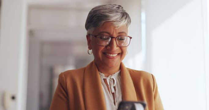 Smartphone, walking and senior business woman in office online networking, email feedback or social media check for corporate success. Happy boss, executive or ceo reading feedback on her cellphone
