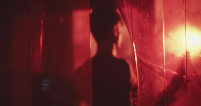 Young man walking out of the bar exist in red lights