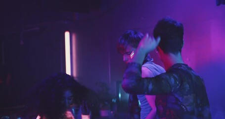 Three lgbt friends daning in blue light at a party