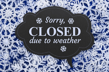 Sorry Closed due to weather chalkboard sign on snowflakes