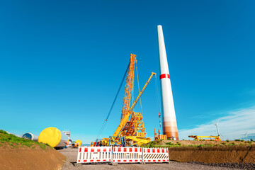 Building and assembling a construction windturbine by Crawler Track Crane - machinery. Farmland...