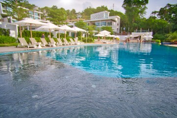 White sand beach and blue sea landscape view of a tropical resort hotel beside modern swimming...