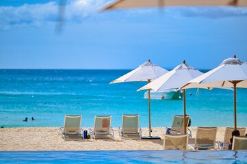 White sand beach and blue sea landscape view of a tropical resort hotel beside modern swimming...