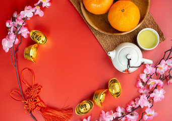 Happy Chinese New Year. Mandarin Oranges, Chinese Gold Sycee, angpao or red packet monetary gift for a symbol of prosperity. Isolated red. Copy space. Usable for wallpaper, greeting card, design.