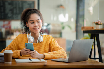 Fototapeta premium American teenage woman sitting in office with laptop, she is a student studying online with laptop at home, university student studying online, online web education concept.