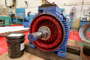 Large induction motor placed in workshop awaiting overhaul maintenance, industrial maintenance work concept and technology.