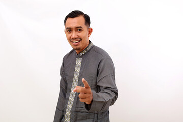 Happy asian man standing while pointing at the camera. Isolated on white background