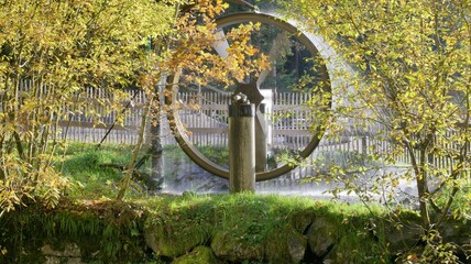 Water wheel behind bushes