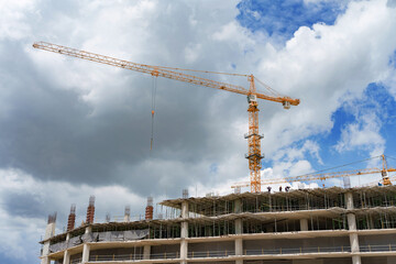 Crane and building under construction against. © Kiimura