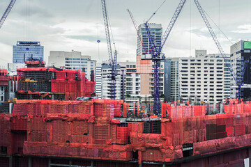 Crane and building under construction against. .and covered with red canvas