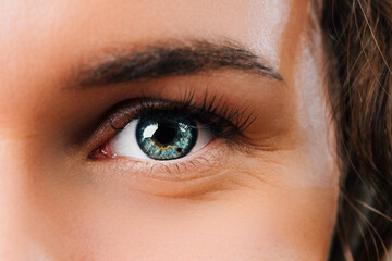 Close up photo of woman blue eye looking at camera.