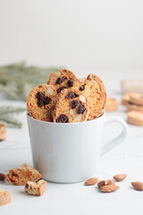 Biscotti in a white cup cantucci cookies with almond and cranberry on white background