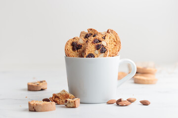 Biscotti in a white cup cantucci cookies with almond and cranberry on white background