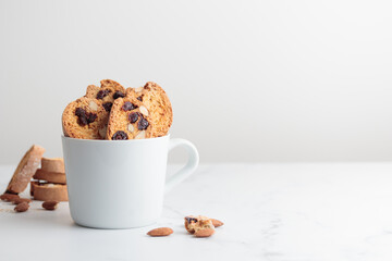 Biscotti in a white cup cantucci cookies with almond and cranberry on white background