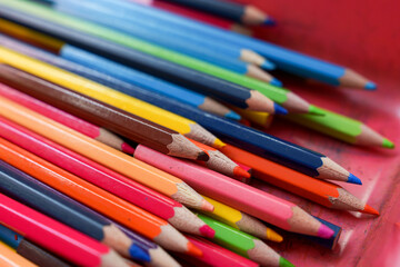 Several colored pencils placed in plastic box.