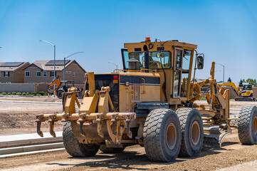 Yellow tractor, construction equipment, road repair.