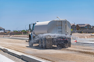 The watering machine waters the road. Road construction. Repair.