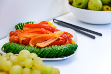 A plate of sliced vegetables in close-up. Pieces of cucumber on a white plate.