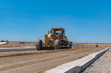 Yellow excavator. Road. Repair. Construction of the highway.