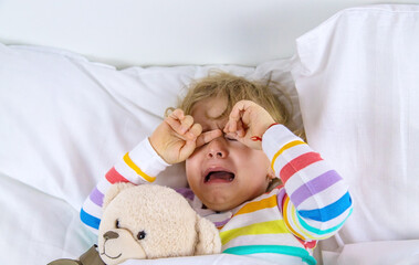 Children are crying in bed. Selective focus.