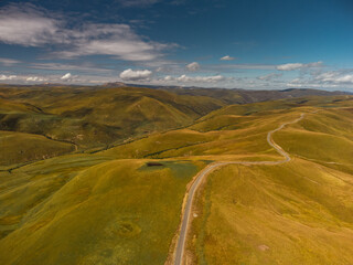Fototapeta premium Car Moving among Green Hills and Forest.