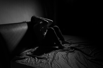 Man with depression sitting in a dark room.  Depression is a low mood that lasts for a long time,...