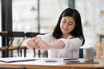 business woman work from home and stretching her body because feel tired after working on tablet computer, Lifestyle woman relax after working at home concept.