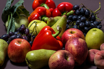 A collection of different colorful vegetables and fruits on a dark background