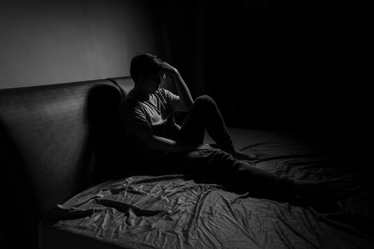 Man with depression sitting in a dark room.  Depression is a low mood that lasts for a long time, and affects your everyday life.