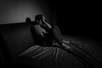 Man with depression sitting in a dark room.  Depression is a low mood that lasts for a long time,...