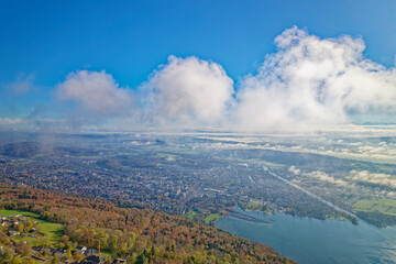 Fototapeta premium Aerial view from village Magglingen Macolin, Canton Bern, over City of Biel Bienne and lake with Aaare River on a blue cloudy autumn day. Photo taken November 10th, 2022, Magglingen, Switzerland.