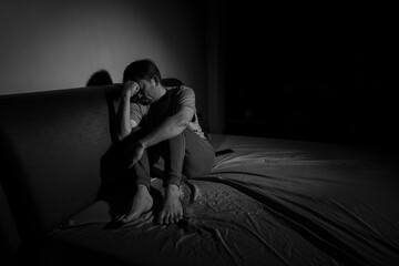 Man with depression sitting in a dark room.  Depression is a low mood that lasts for a long time, and affects your everyday life.