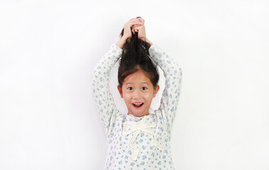 Excited young Asian child girl pick her hair up isolated on white background.